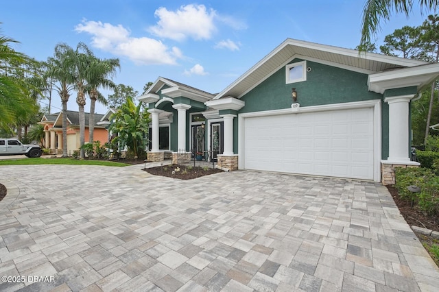 109 Edward Dr, Palm Coast, FL 32164 - single story home with decorative driveway, stucco siding, a garage, and stone siding