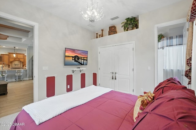 109 Edward Dr, Palm Coast, FL 32164 - bedroom featuring light wood finished floors, a chandelier, and a closet