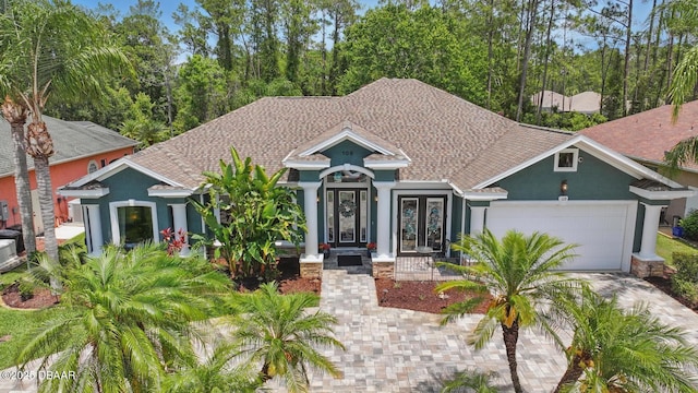 109 Edward Dr, Palm Coast, FL 32164 - view of front of property featuring stucco siding, a garage, french doors, driveway, and roof with shingles