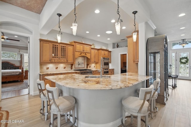 109 Edward Dr, Palm Coast, FL 32164 - kitchen featuring a kitchen bar, light wood finished floors, recessed lighting, range, and light stone counters