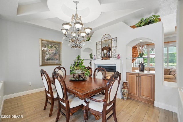 109 Edward Dr, Palm Coast, FL 32164 - dining room with light wood finished floors, a chandelier, and a glass covered fireplace