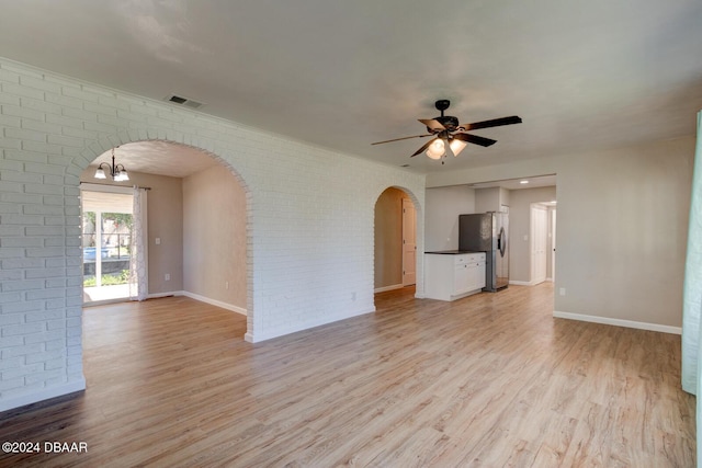 13 Highridge Rd, Daytona Beach, FL 32117 - unfurnished living room featuring arched walkways, brick wall, light wood finished floors, and a ceiling fan