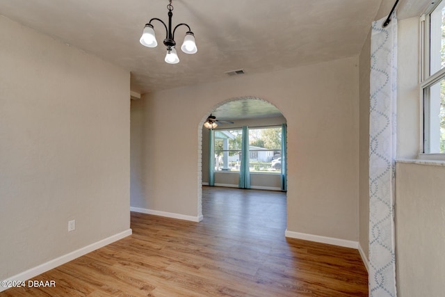 13 Highridge Rd, Daytona Beach, FL 32117 - spare room with arched walkways, a ceiling fan, wood finished floors, and a chandelier