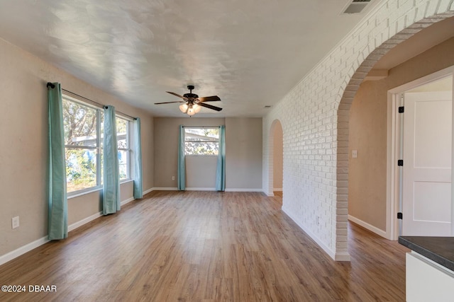13 Highridge Rd, Daytona Beach, FL 32117 - unfurnished room featuring arched walkways, a ceiling fan, light wood-style floors, and brick wall