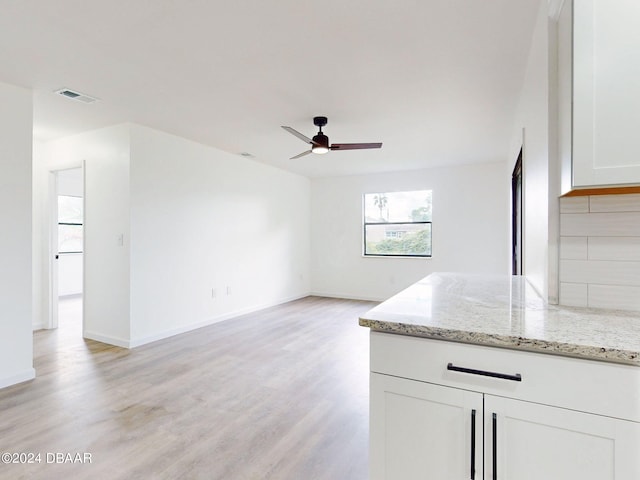 unfurnished living room with ceiling fan and light wood-type flooring