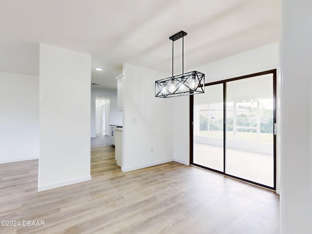 unfurnished dining area featuring a chandelier and light hardwood / wood-style floors