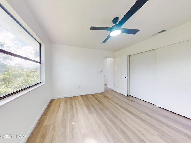 unfurnished bedroom featuring light hardwood / wood-style floors, ceiling fan, and a closet