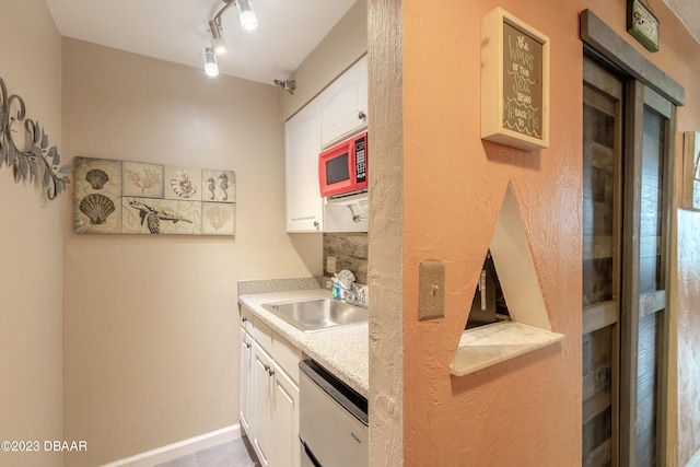 kitchen with white cabinetry, track lighting, sink, and dishwasher