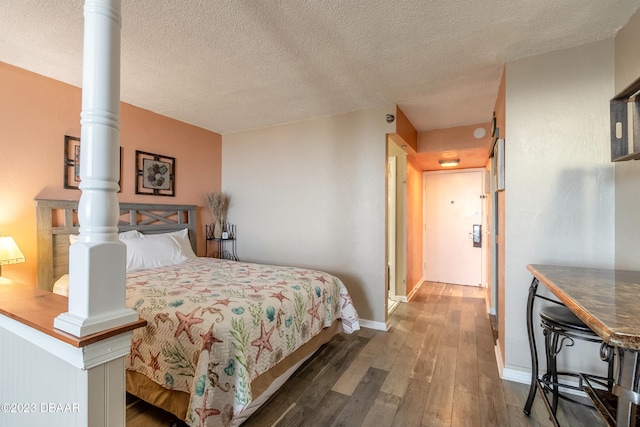 bedroom with a textured ceiling and dark hardwood / wood-style floors