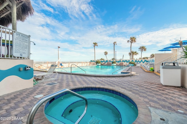 view of swimming pool featuring a community hot tub and a patio