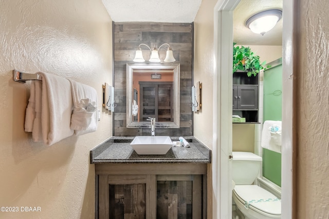 bathroom featuring toilet, vanity, and a textured ceiling