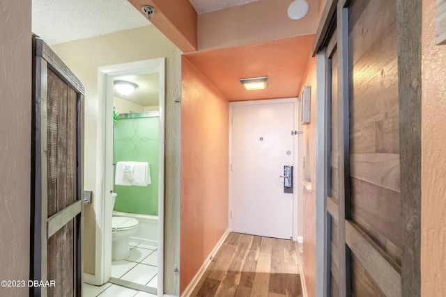 corridor featuring wood-type flooring and a textured ceiling