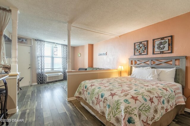 bedroom with a textured ceiling and dark hardwood / wood-style floors