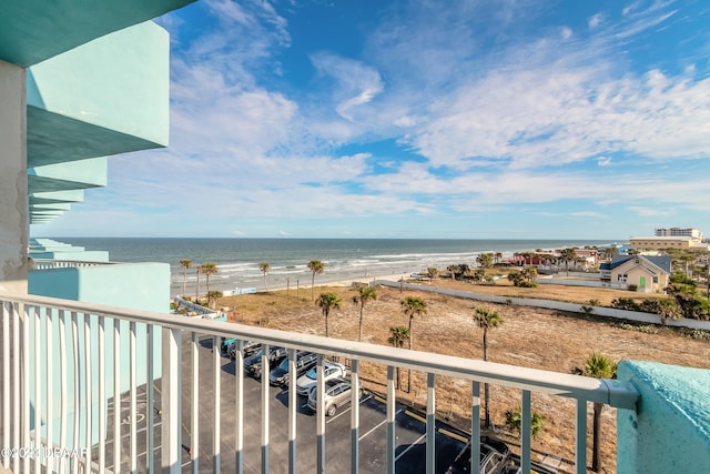 balcony featuring a beach view and a water view