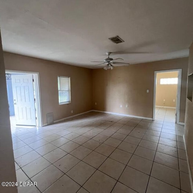 spare room with ceiling fan and light tile patterned floors