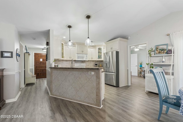 kitchen featuring decorative light fixtures, kitchen peninsula, backsplash, stainless steel refrigerator with ice dispenser, and dark hardwood / wood-style flooring