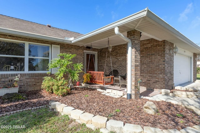 entrance to property featuring a porch and a garage