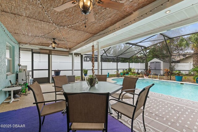 exterior space with ceiling fan, a lanai, a patio, and a shed