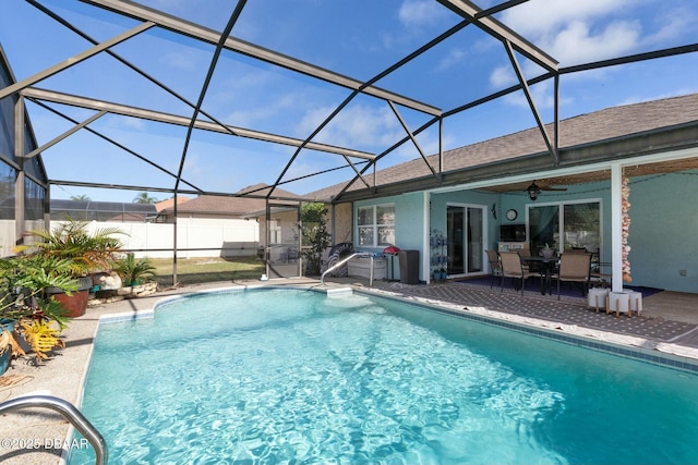 view of swimming pool featuring ceiling fan, a lanai, and a patio