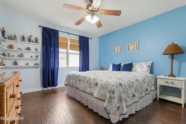 bedroom featuring dark wood-type flooring, a textured ceiling, and ceiling fan