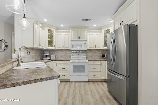 kitchen featuring sink, white appliances, light wood-type flooring, backsplash, and pendant lighting