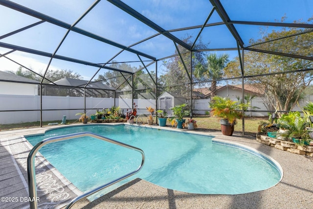 view of pool with a lanai and a storage shed