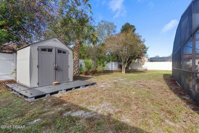 view of yard with glass enclosure and a storage shed