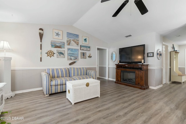 living room featuring lofted ceiling, ceiling fan, and wood-type flooring