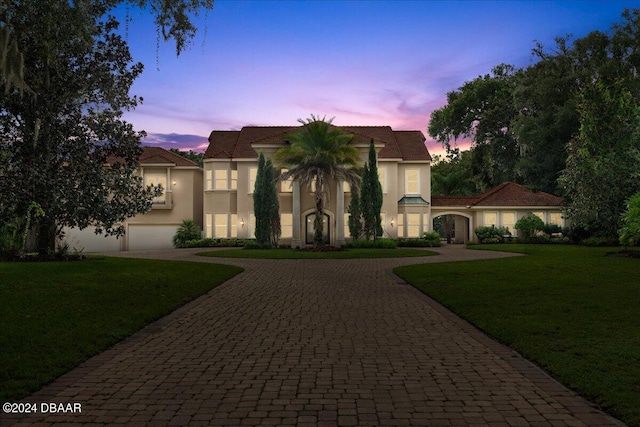 mediterranean / spanish-style house featuring a garage and a yard