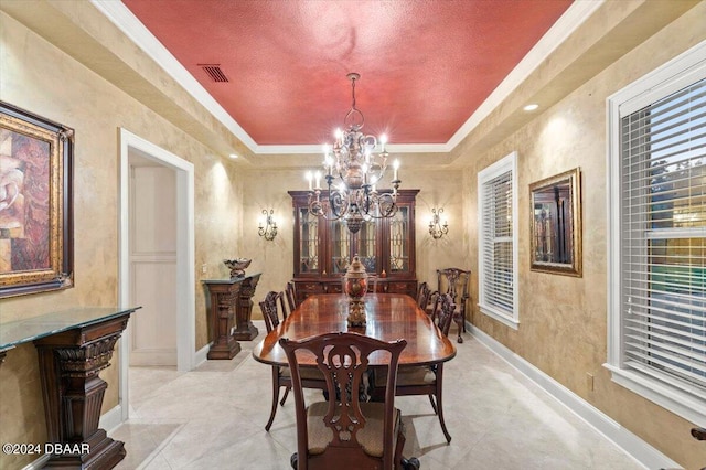 dining room featuring a notable chandelier, a textured ceiling, crown molding, and a tray ceiling