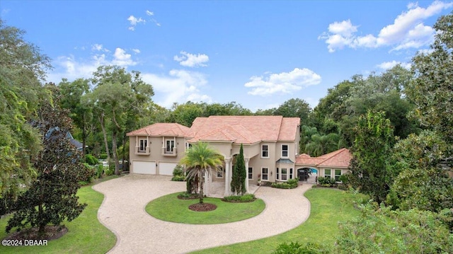 mediterranean / spanish-style house with a garage and a front yard