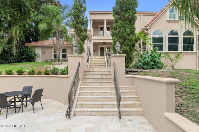 mediterranean / spanish-style house featuring a balcony and a patio area