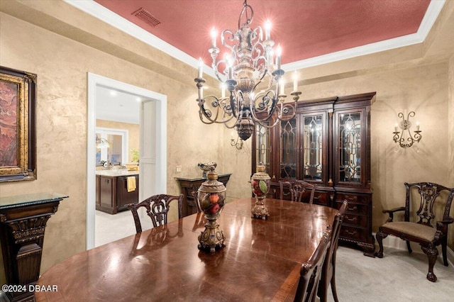 carpeted dining space with ornamental molding and a tray ceiling