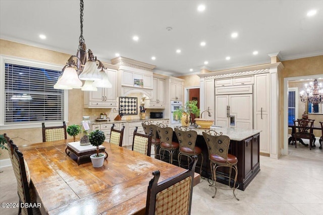 tiled dining room with a chandelier and ornamental molding