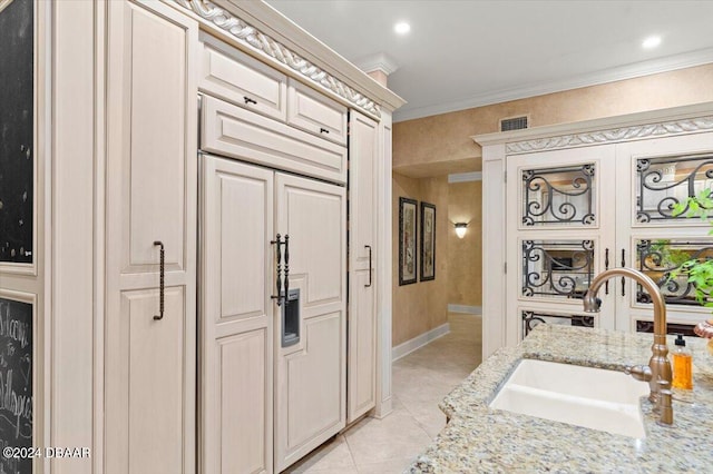 bathroom with tile patterned flooring, sink, and crown molding