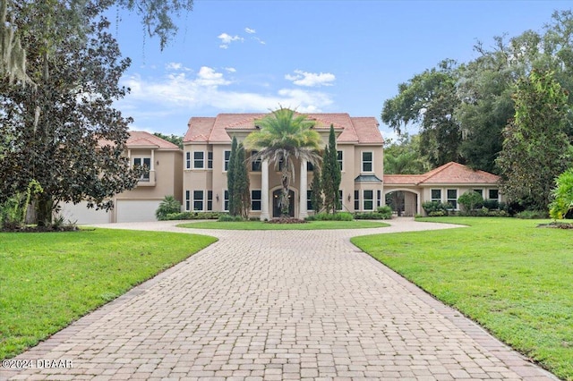 mediterranean / spanish-style home featuring a garage and a front yard