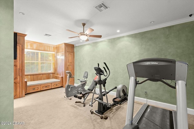 workout area featuring ornamental molding, a textured ceiling, light colored carpet, and ceiling fan