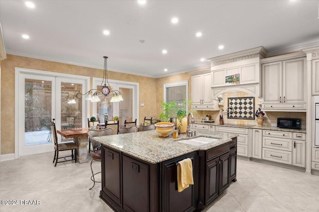 kitchen with sink, ornamental molding, light stone countertops, hanging light fixtures, and french doors