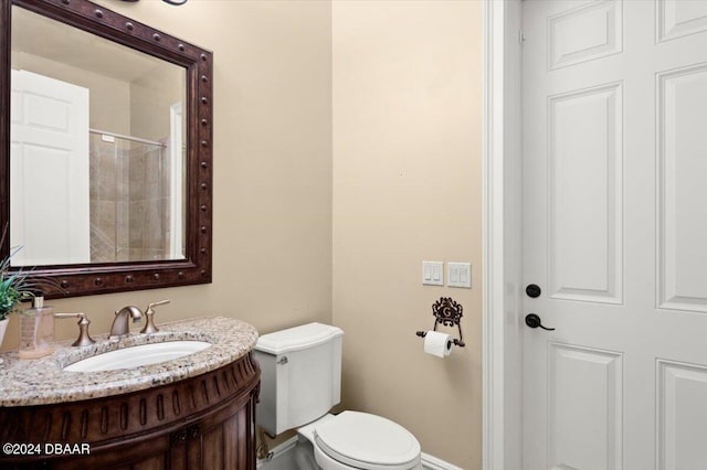 bathroom with vanity, toilet, and tiled shower