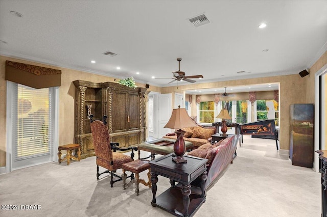 living room featuring ceiling fan, light carpet, and ornamental molding