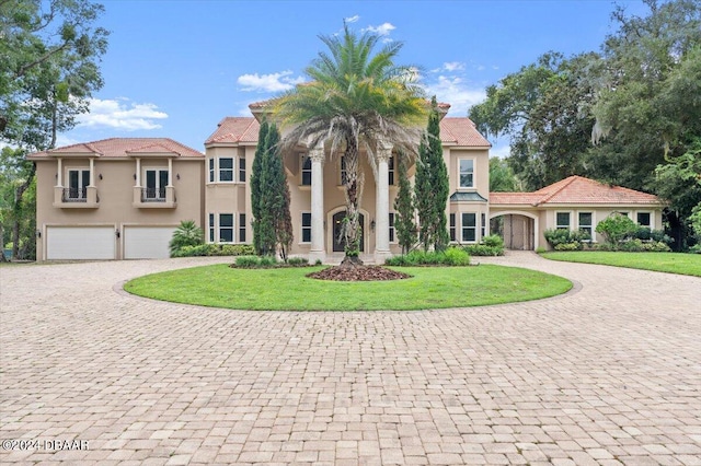 mediterranean / spanish-style home featuring a garage and a front lawn