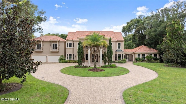 mediterranean / spanish house featuring a garage and a front yard