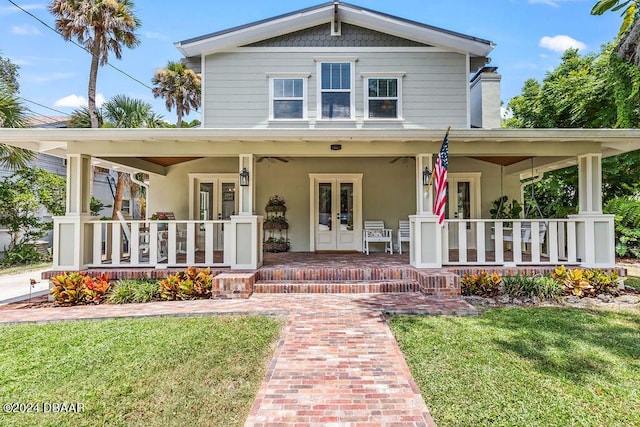 view of front of property with french doors, a porch, and a front yard