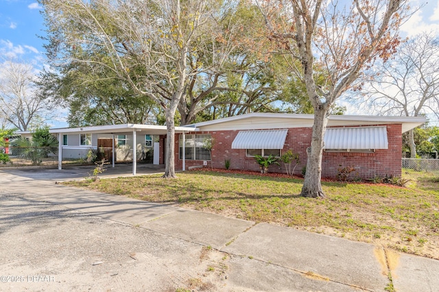 single story home featuring a carport and a front yard