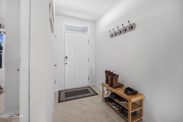 doorway to outside with light tile patterned flooring and baseboards