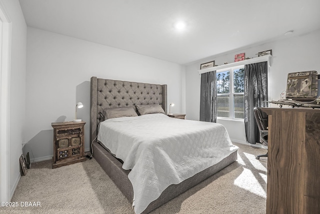 bedroom with baseboards and light colored carpet