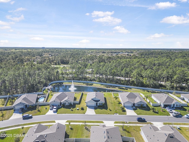 drone / aerial view with a residential view, a water view, and a view of trees