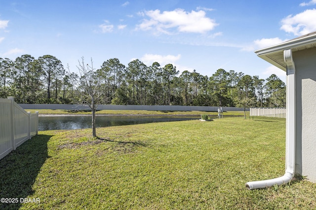 view of yard featuring a water view and fence