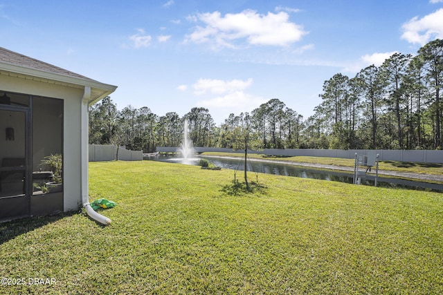 view of yard featuring a water view and fence