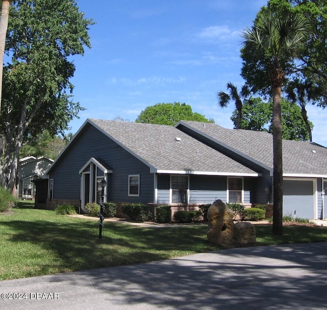 single story home featuring a front lawn and a garage